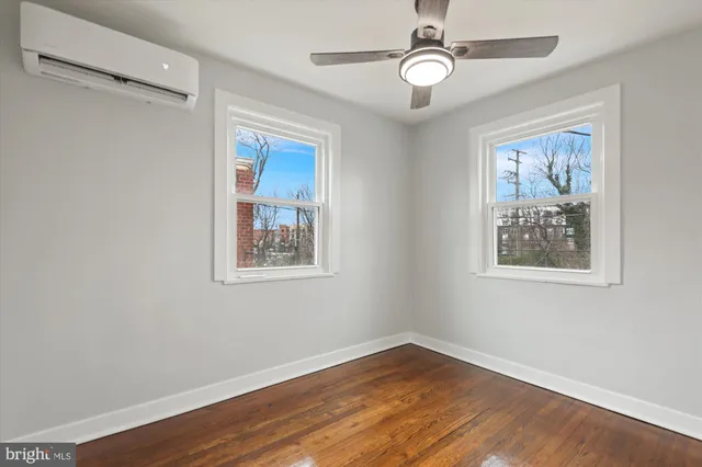 a view of a big room with wooden floor and windows
