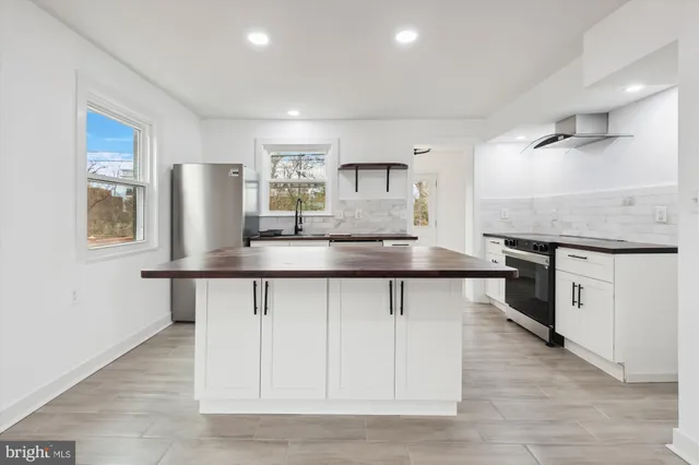 a kitchen with granite countertop a sink cabinets and stainless steel appliances