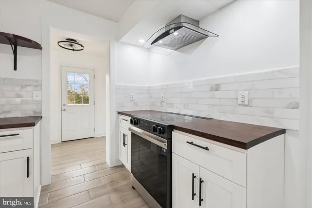 a kitchen with a stove cabinets and wooden floor
