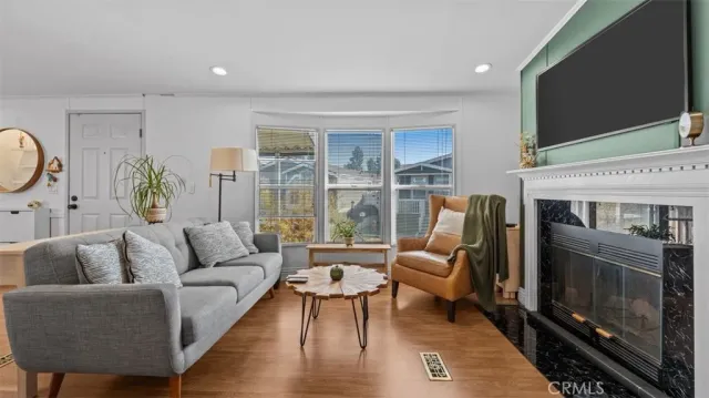 a living room with furniture a flat screen tv and a fireplace