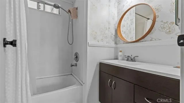 a bathroom with a sink vanity mirror and a bathtub