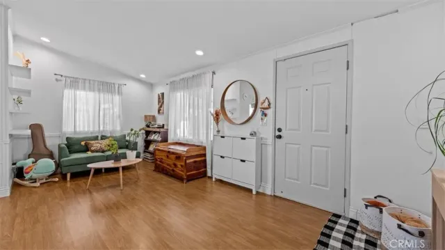 a living room with furniture a wooden floor and a large window