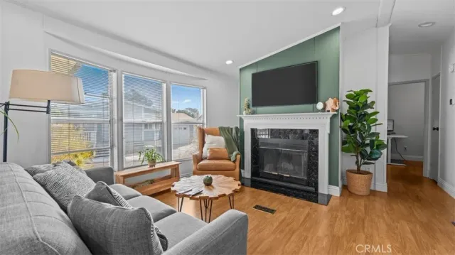 a living room with furniture a flat screen tv and a fireplace