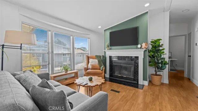 a living room with furniture a flat screen tv and a fireplace