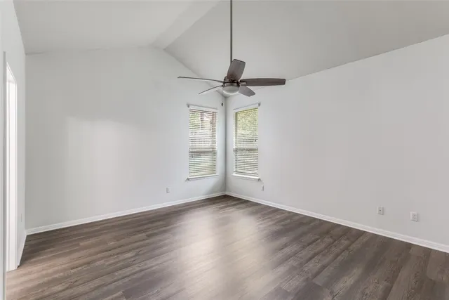 a view of room with window ceiling fan and hardwood floor