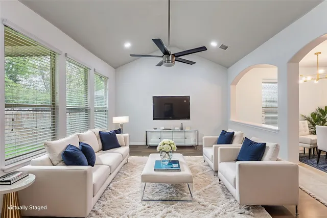 a living room with furniture a large window and a flat screen tv