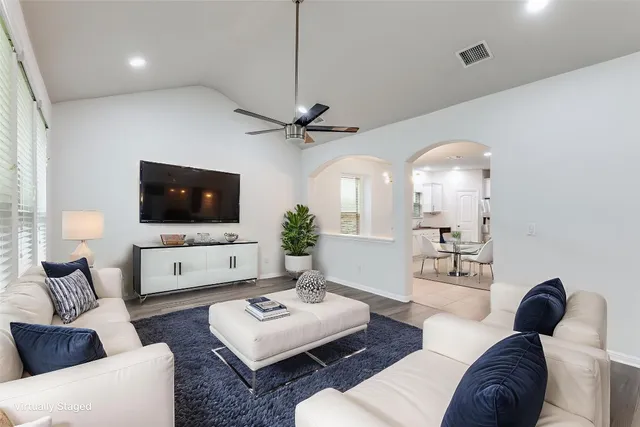 a living room with furniture a flat screen tv and a chandelier