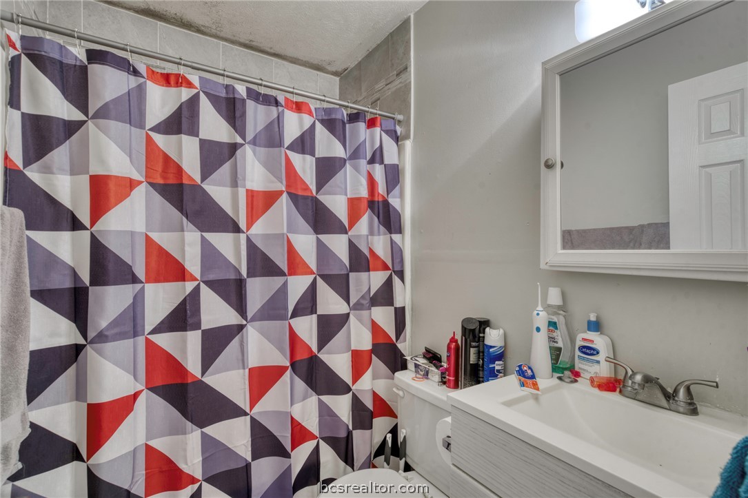 1908 Barak Lane, Unit 14 Bryan, TX 77802 - Photo 10 of 10 Bathroom featuring vanity, toilet, and a shower with shower curtain