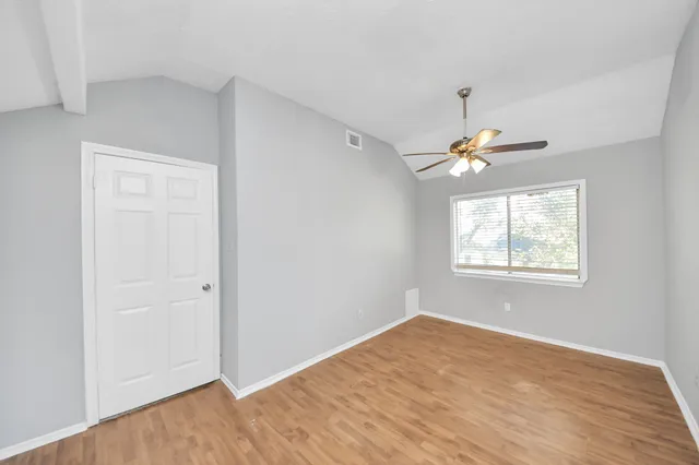 a view of an empty room with wooden floor & closet