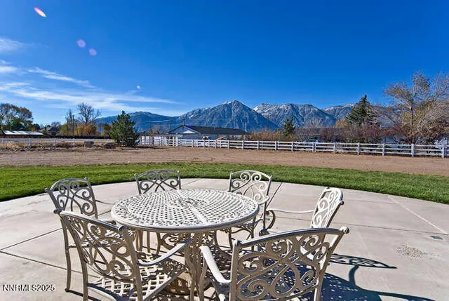 a patio with a table and chairs and potted plants