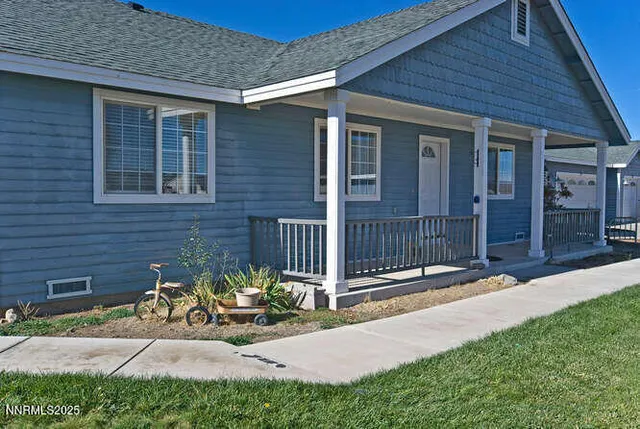 a view of a house with a small yard and wooden fence