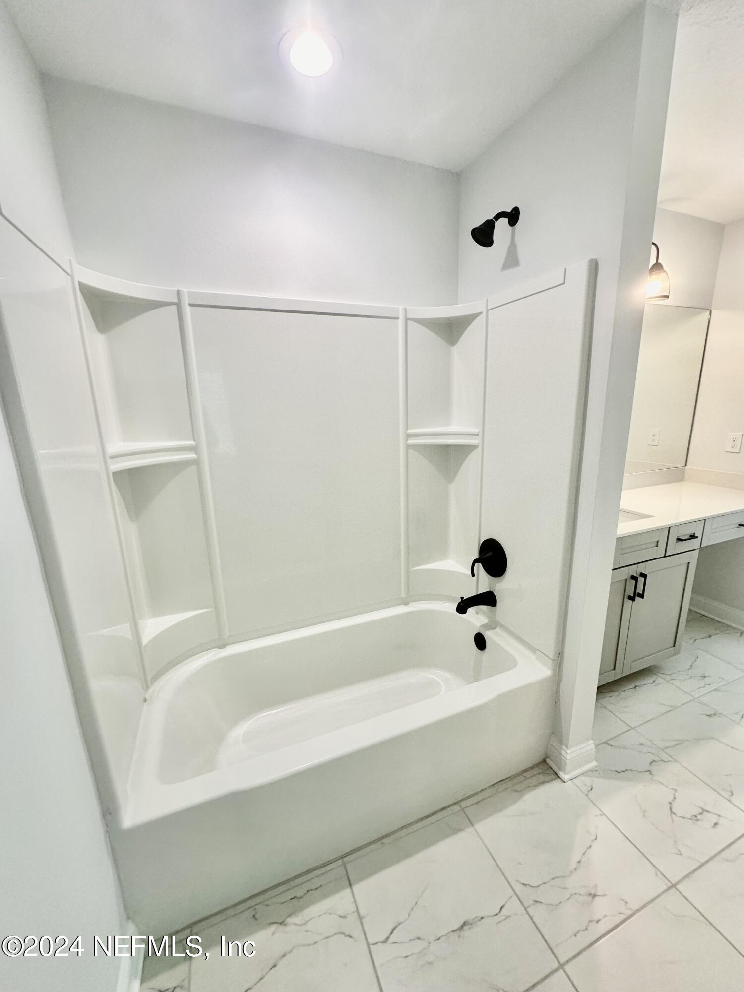 236 Wildlight Avenue Yulee, FL 32097 - Photo 5 of 10 a white bath tub sitting next to a white sink and vanity