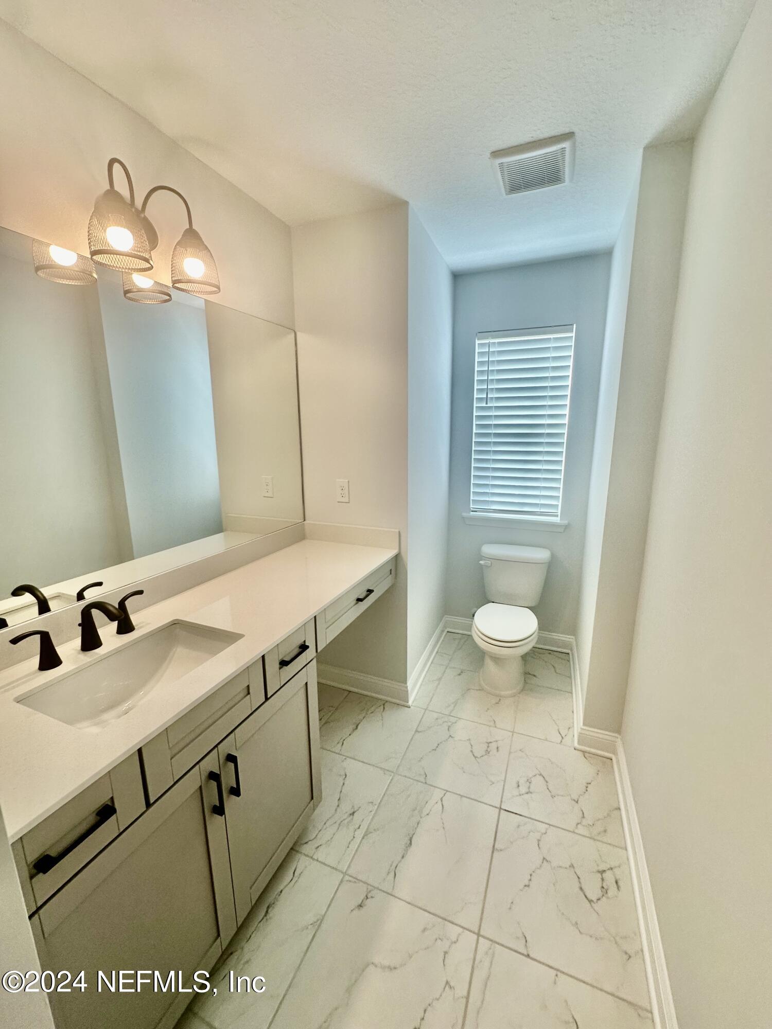 236 Wildlight Avenue Yulee, FL 32097 - Photo 6 of 10 a bathroom with a sink a toilet and a mirror