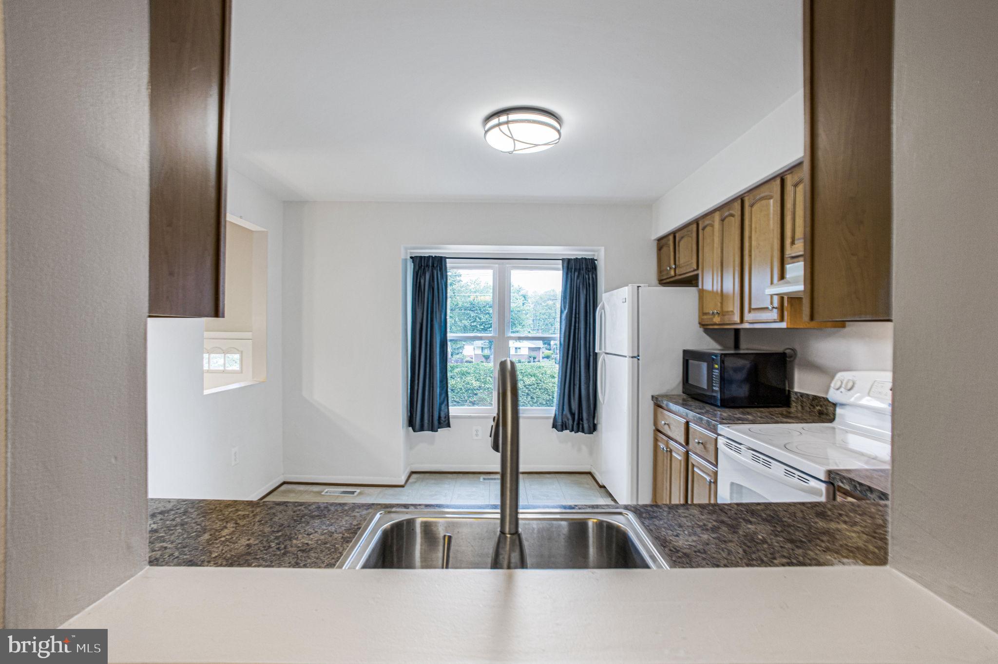 2830 Schoolhouse Circle Silver Spring, MD 20902 - Photo 12 of 58 a kitchen with granite countertop a sink a counter top space cabinets and stainless steel appliances