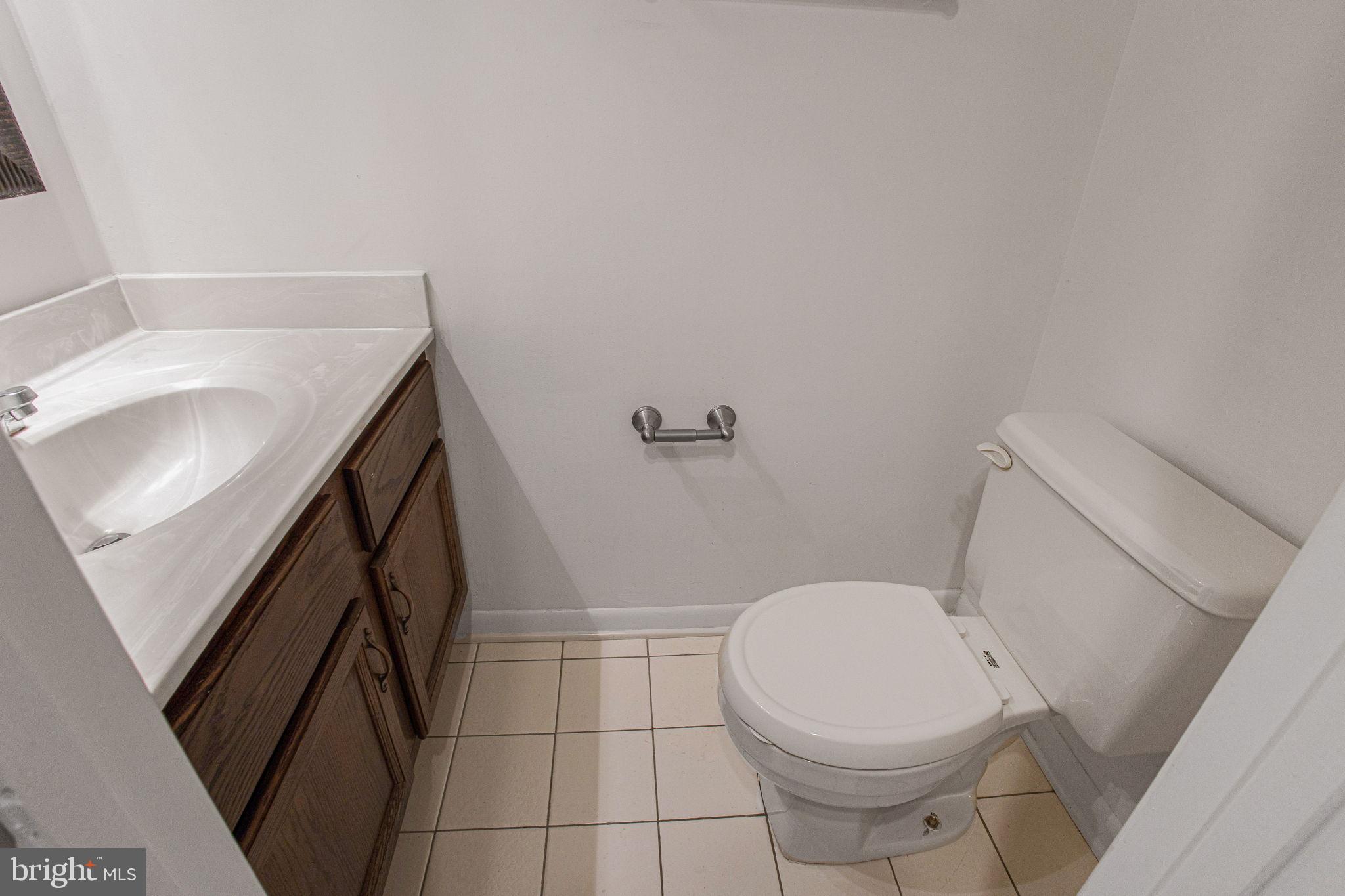 2830 Schoolhouse Circle Silver Spring, MD 20902 - Photo 18 of 58 a white toilet sitting next to a sink and vanity