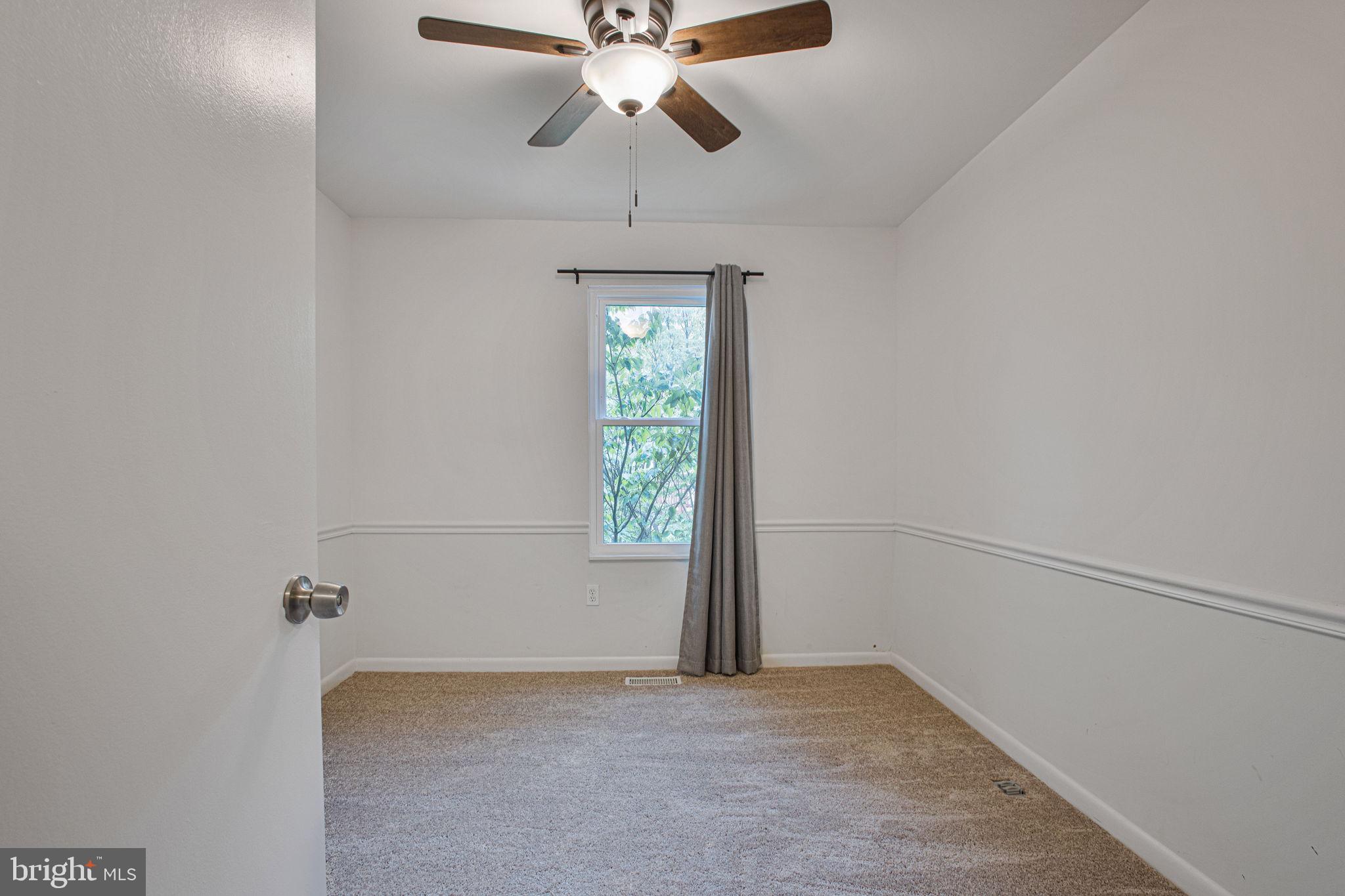 2830 Schoolhouse Circle Silver Spring, MD 20902 - Photo 32 of 58 an empty room with windows and fan