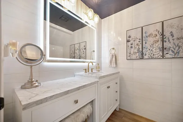 a bathroom with a granite countertop sink a mirror and vanity