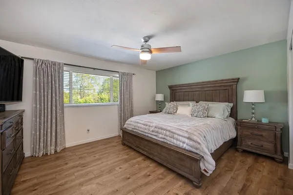 a bedroom with a bed a chandelier and a flat tv