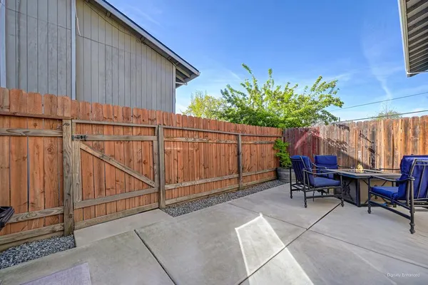 a backyard of a house with chairs plants and wooden fence