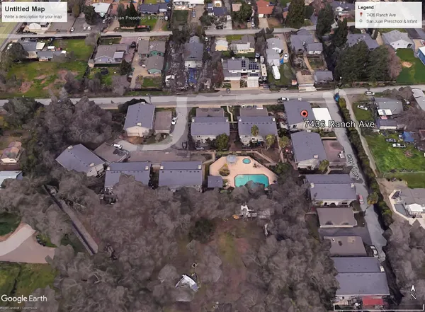 an aerial view of a house with a yard and a large tree