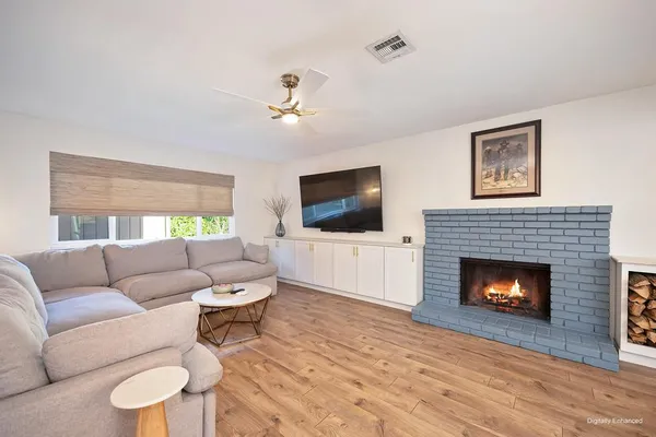a living room with furniture a flat screen tv and a fireplace