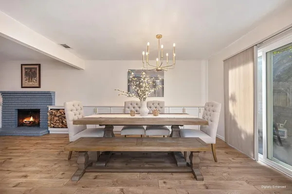 a view of a dining room with furniture a chandelier and wooden floor