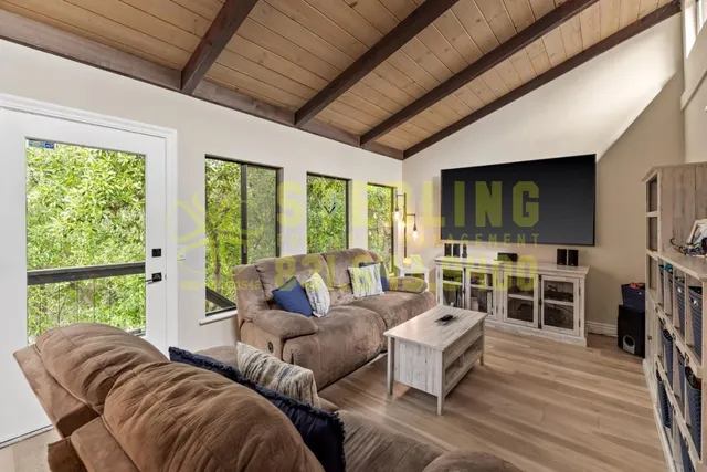 a living room with furniture a flat screen tv and bookshelf