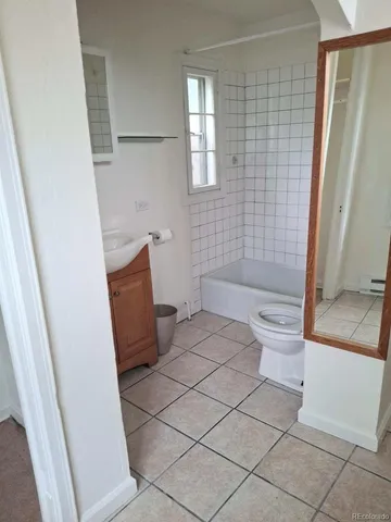 a bathroom with a granite countertop bathtub and toilet
