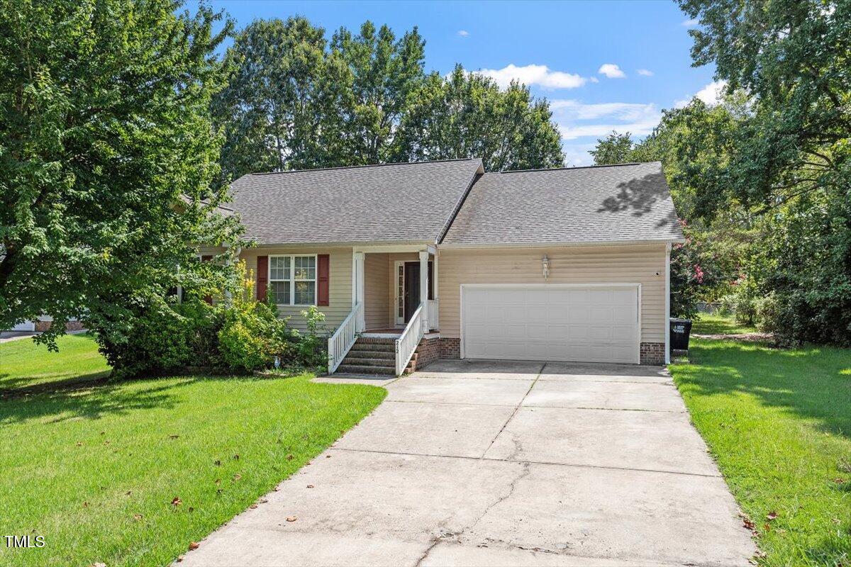 a front view of a house with yard and green space