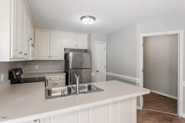 a kitchen with stainless steel appliances granite countertop a refrigerator and a sink