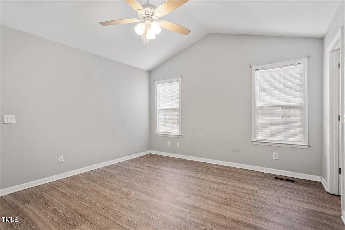 212 Webfoot Drive Garner, NC 27529 - Photo 16 of 26 an empty room with wooden floor fan and windows
