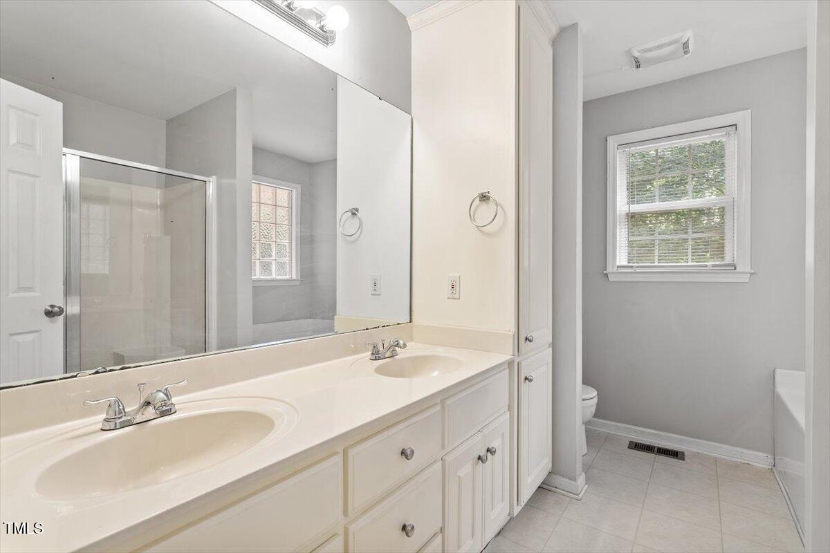 212 Webfoot Drive Garner, NC 27529 - Photo 17 of 26 a bathroom with a double vanity sink a mirror and a