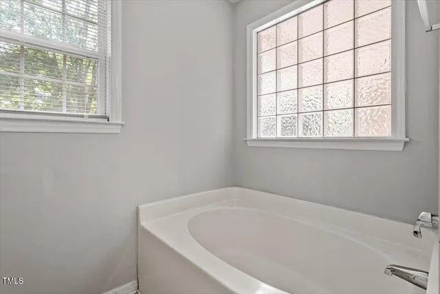 a white bath tub sitting next to a window