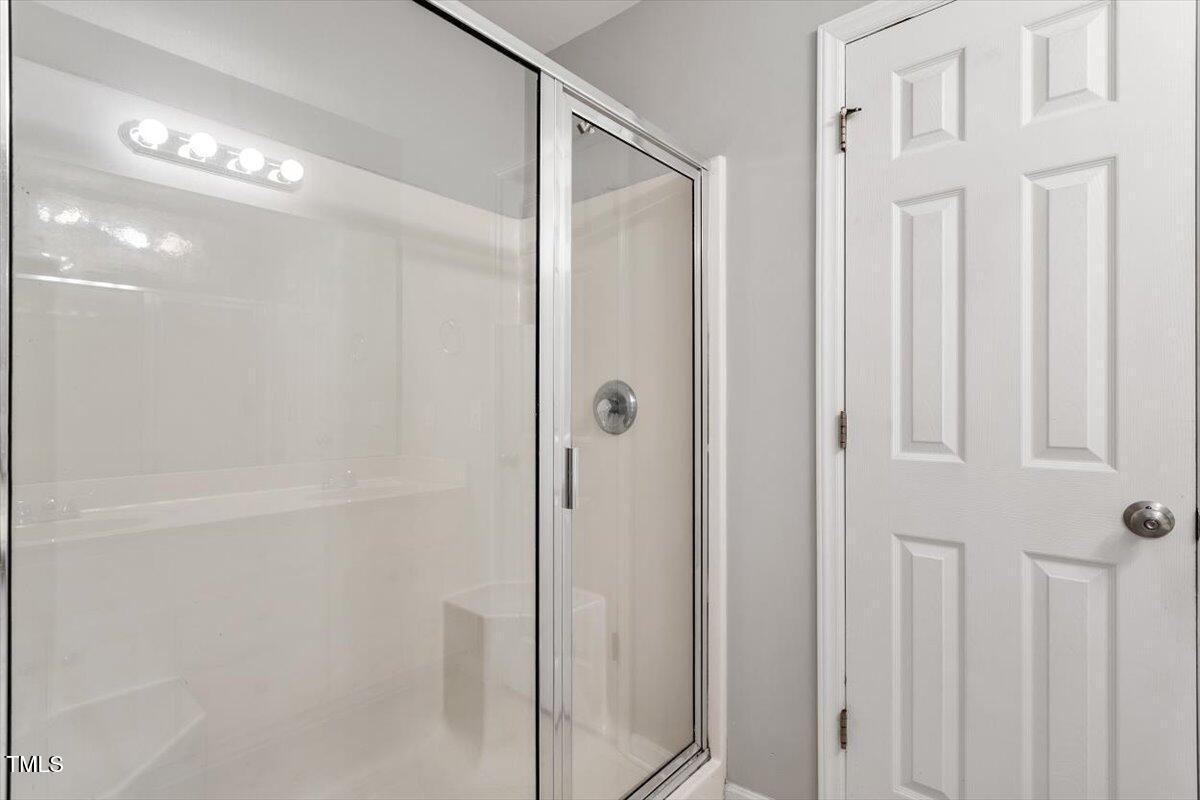 212 Webfoot Drive Garner, NC 27529 - Photo 19 of 26 a bathroom with a glass shower door