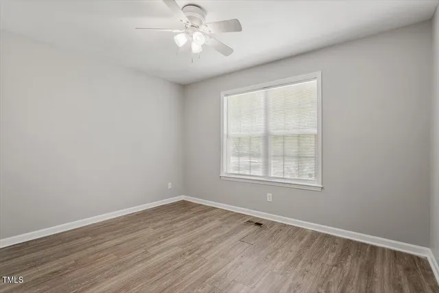 wooden floor in an empty room with a window