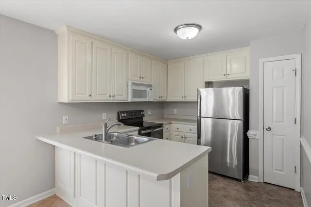 a kitchen with a sink a refrigerator and cabinets