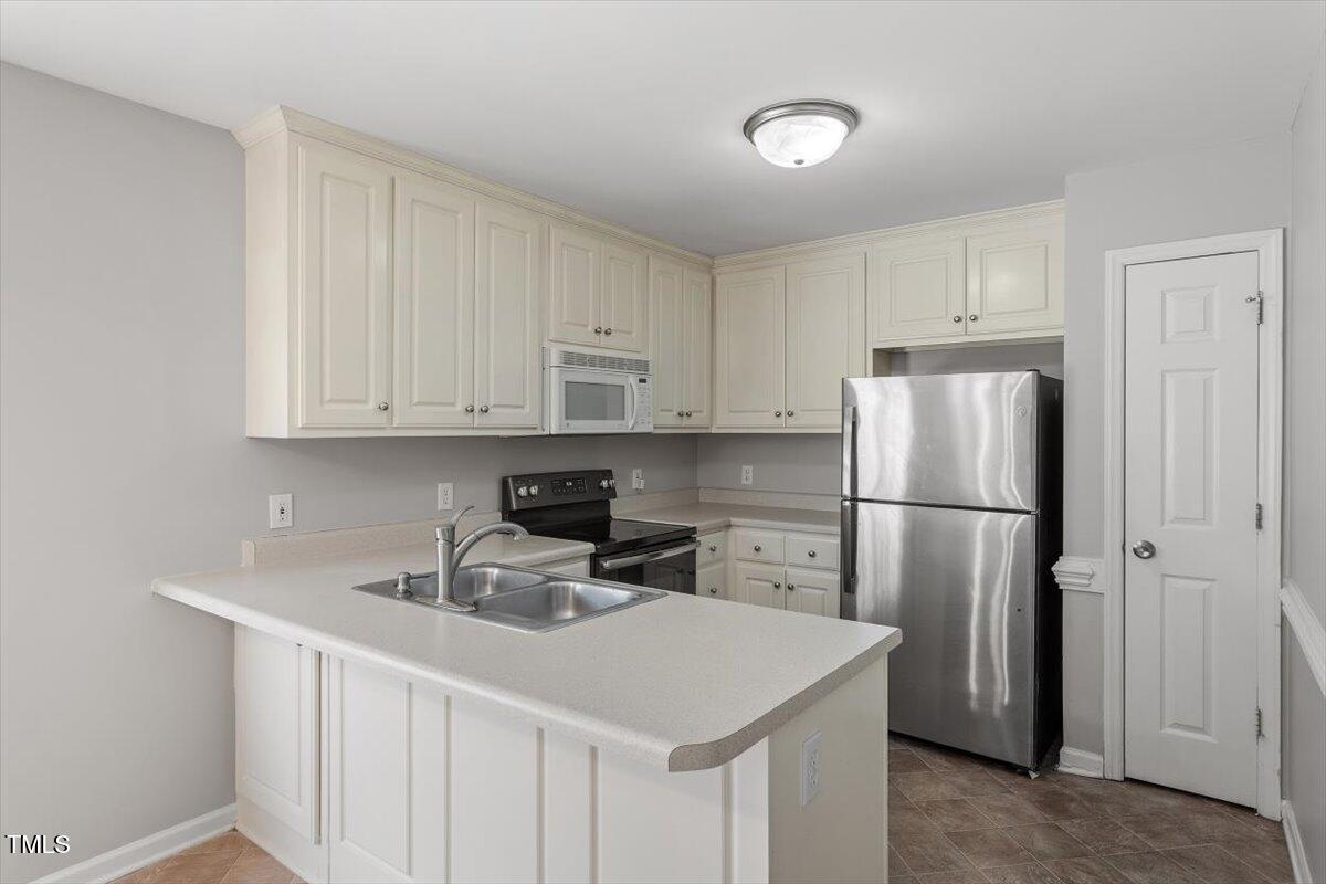 212 Webfoot Drive Garner, NC 27529 - Photo 10 of 26 a kitchen with a sink a refrigerator and cabinets