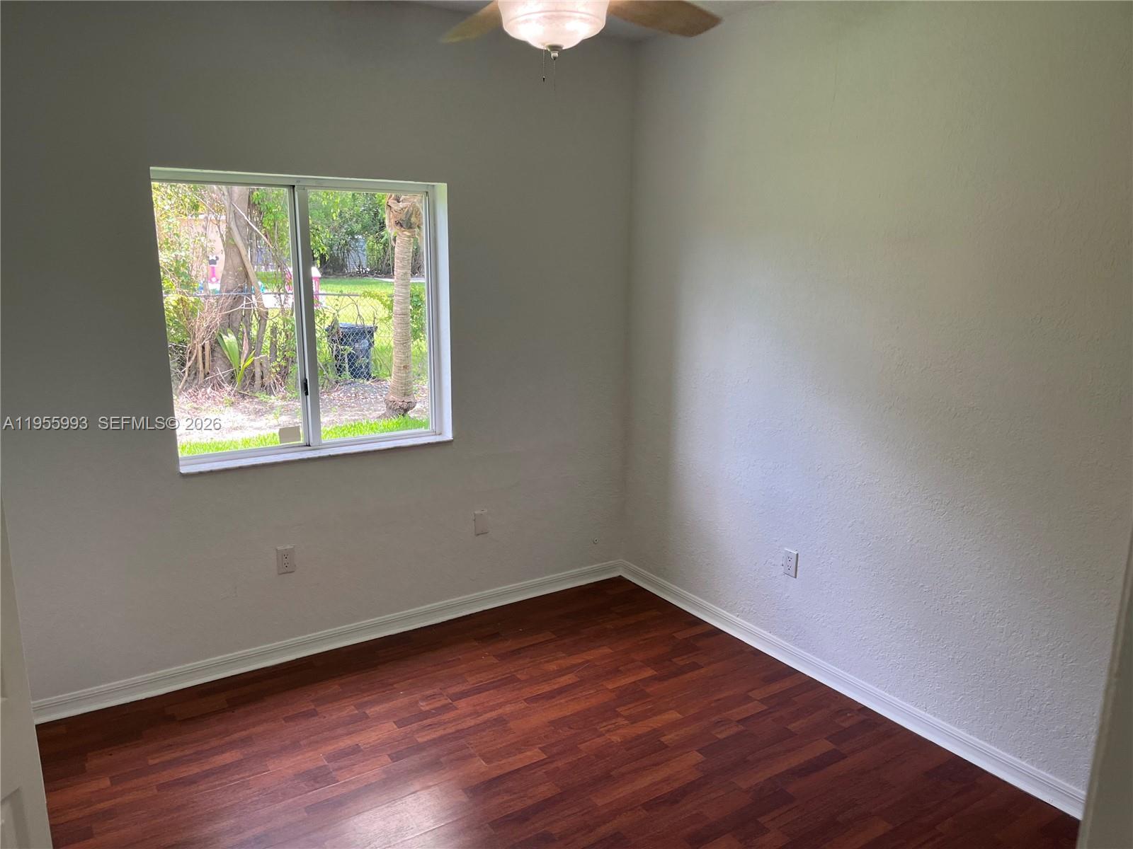 12997 Southwest 219th Terrace, Unit 12997 Miami, FL 33170 - Photo 12 of 24 an empty room with wooden floor and windows