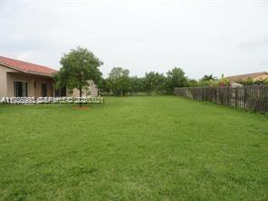 12997 Southwest 219th Terrace, Unit 12997 Miami, FL 33170 - Photo 21 of 24 a backyard of a house with lots of green space