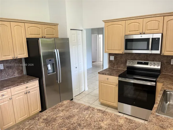a kitchen with stainless steel appliances granite countertop a refrigerator stove and sink