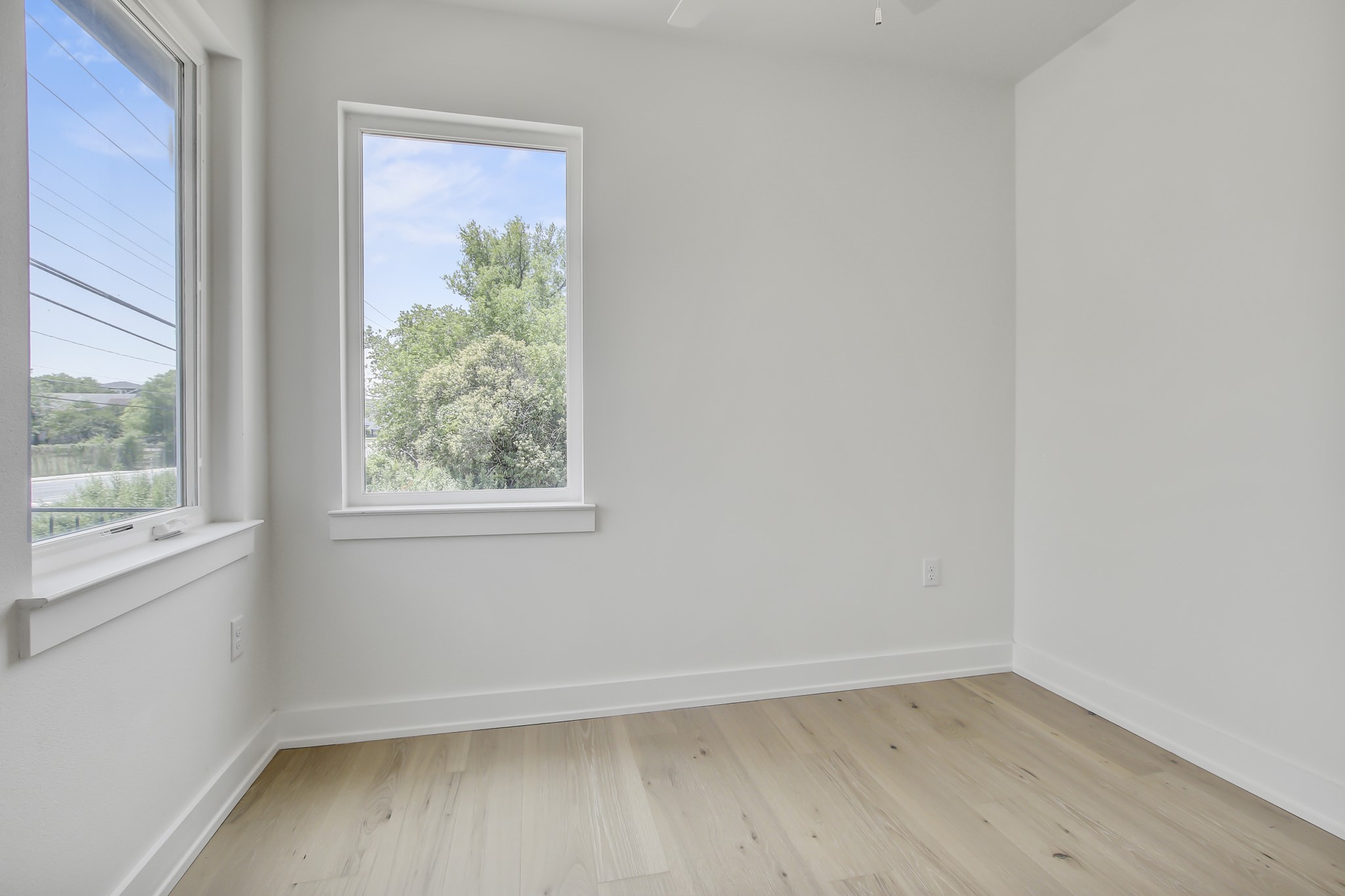 4127 East 12th Street, Unit 8 Austin, TX 78721 - Photo 24 of 32 Unfurnished room with light wood-style flooring, baseboards, and ceiling fan