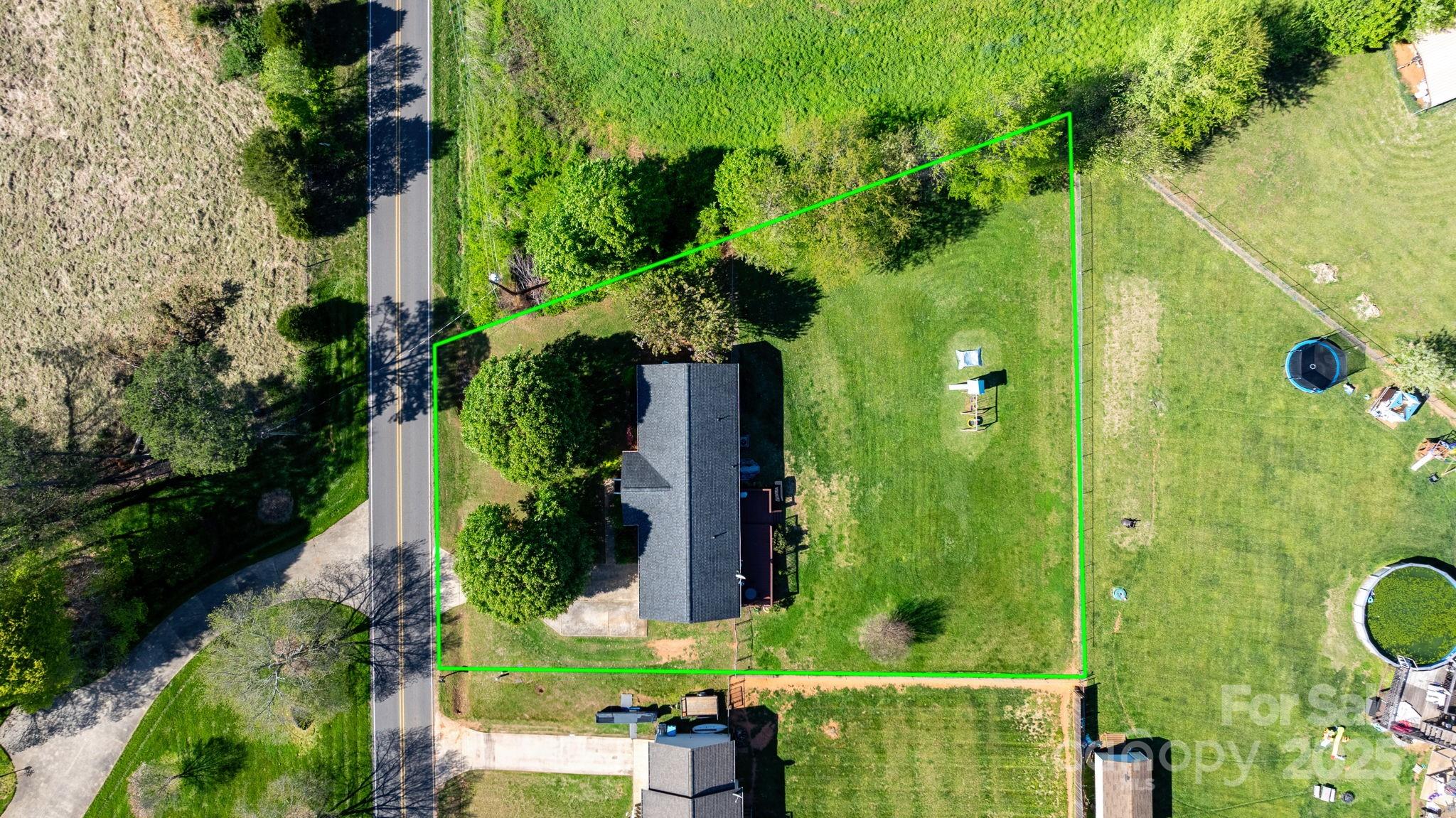 an aerial view of a residential houses with yard
