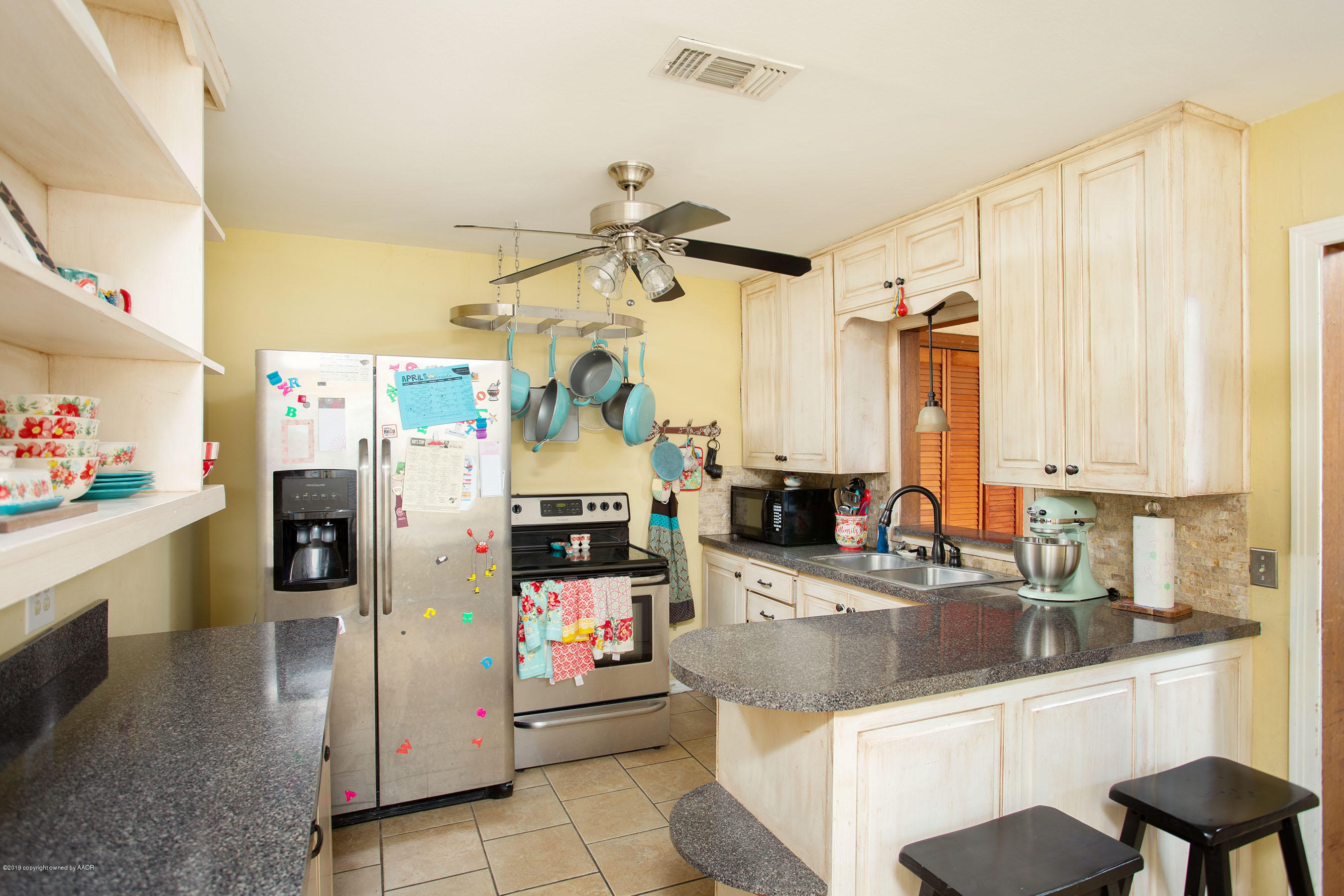 4122 South Travis Street Amarillo, TX 79110 - Photo 6 of 18 a kitchen with a sink refrigerator and cabinets