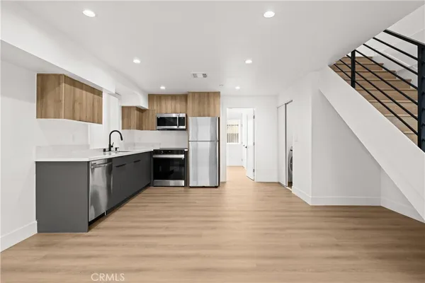 a large kitchen with stainless steel appliances kitchen island a large counter top and a stove top oven