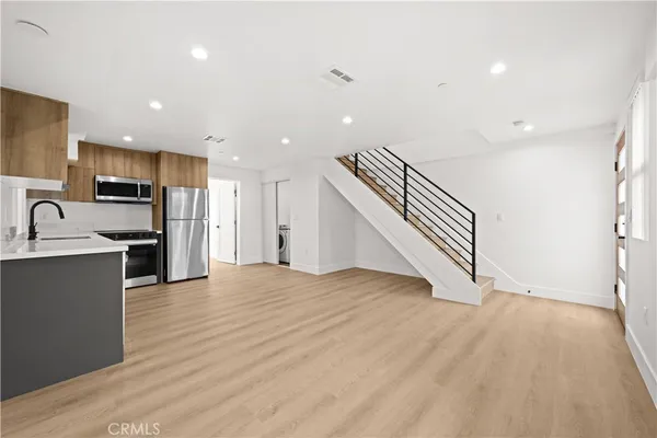 a view of kitchen with sink and refrigerator