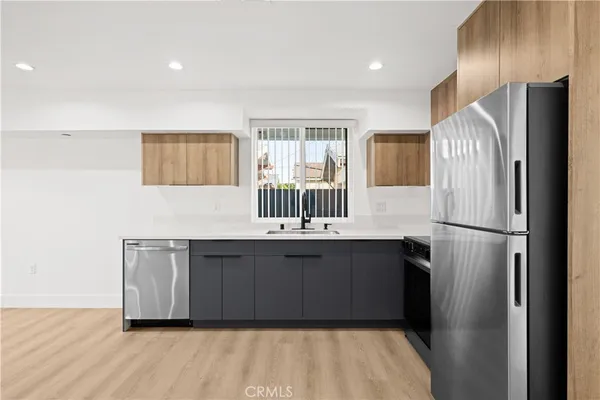 a kitchen with a refrigerator sink and cabinets