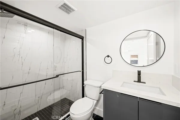 a bathroom with a sink a toilet and a mirror