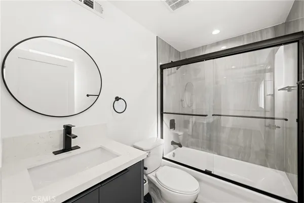 a bathroom with a sink toilet and a mirror