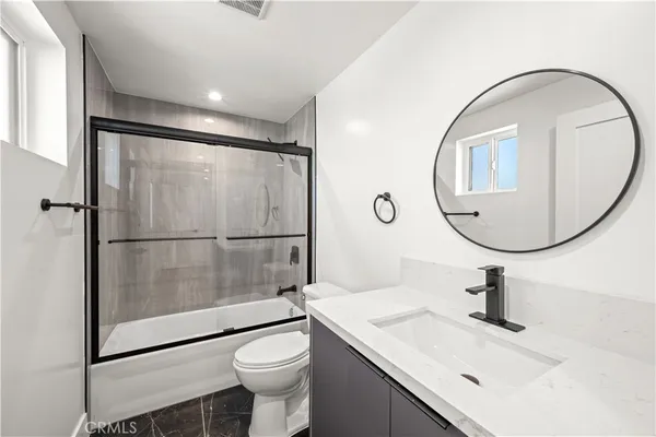 a bathroom with a sink mirror toilet and glass shower