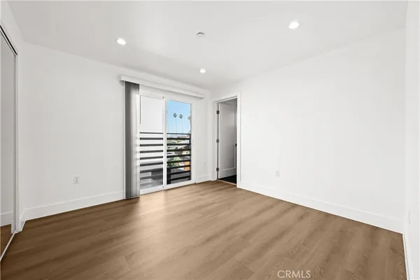 an empty room with wooden floor and closet
